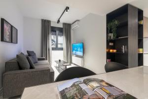 アテネにあるHeritage Boutique Apartmentsのソファとテーブルのあるリビングルーム