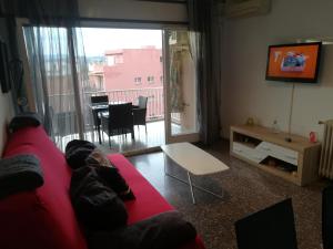 リョレート・デ・マルにあるApartamento El Vilatgeのリビングルーム(赤いソファ、テーブル付)