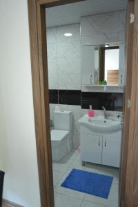 W łazience znajduje się umywalka, toaleta i lustro. w obiekcie Yeşilyurt Residence w mieście Izmir