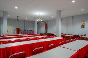 an empty room with red chairs and tables at RedDoorz @ Hotel Grand Aulia Majene in Majene