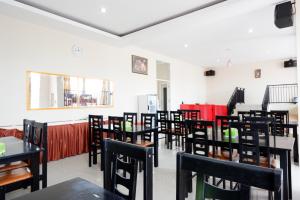 uma sala de jantar com cadeiras e mesas pretas e vermelhas em RedDoorz @ Hotel Grand Aulia Majene em Majene