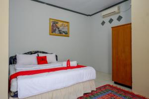a bedroom with a bed with a red ribbon on it at RedDoorz @ Hotel Aulia Majene in Majene