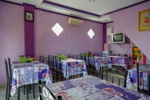 een kamer met tafels en stoelen en paarse muren bij RedDoorz @ Hotel Aulia Majene in Majene +20 foto's