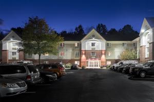 a large building with cars parked in a parking lot at Candlewood Suites Durham - RTP by IHG in Durham