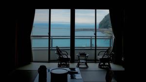 a room with a large window with a view of the ocean at Sanyoso in Tosa