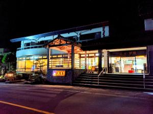 a building with a sign in front of it at night at Sanyoso in Tosa