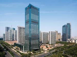 a tall glass building in a city with tall buildings at The Langham, Hefei in Hefei