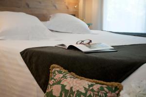 a book and glasses on top of a bed at Arrels d'Emporda in Palafrugell