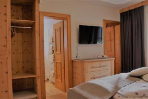 a bedroom with a bed and a tv on the wall at Appartements Griesserhof in Oetz