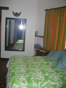 a bedroom with a bed and a large mirror at Unelma Bungalows in Bucer&iacute;as