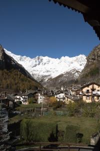 een dorp met sneeuw bedekte bergen op de achtergrond bij Maison De Meuny in Courmayeur