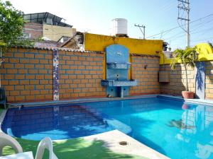 a swimming pool in front of a brick wall at Hotel Real Jojutla in Jojutla de Juárez