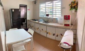 a kitchen with a sink and a table and a refrigerator at Hotel Rasa Sayang Artisan Inn Jelebu in Kampong Seperi