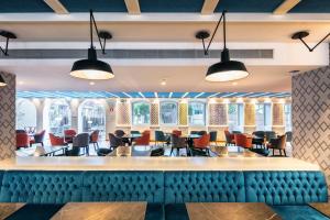 a bar with chairs and tables in a restaurant at Catalonia Porto in Porto