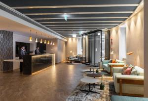 波尔图Catalonia Porto的大厅配有沙发,大楼内设有一间酒吧