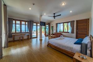 Schlafzimmer mit einem Kingsize-Bett und einem TV in der Unterkunft Le Grand Bleu Hotel in Wok Tum