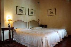 a bedroom with two beds and a table with a lamp at Hotel La Torre in Torreglia