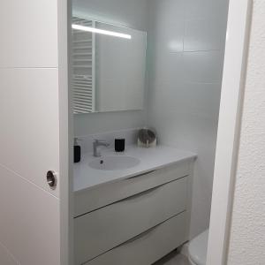 a white bathroom with a sink and a mirror at STUDIO 28 m2 TOUT CONFORT NEUF LABEL 3 ETOILES 4 PERSONNES CYBELE in Brides-les-Bains +7 photos