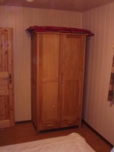 ein Holzschrank in der Ecke eines Zimmers in der Unterkunft Halmis FeWo in Derenburg