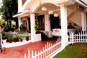 Homested Homestay Fort Kochi في كوتشي: حاجز أبيض أمام المنزل