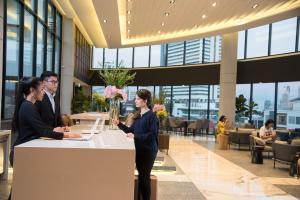 a woman standing at a counter in a lobby at Amanta Hotel & Residence Sathorn in Bangkok