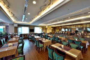台中市にあるShinkansen Grand Hotelの木製テーブルと緑の椅子が備わるレストラン