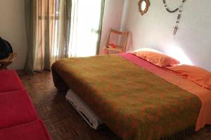 1 dormitorio con 1 cama y 1 silla roja en Appartamento Residence nel Parco, en Camigliatello Silano