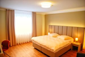 a bedroom with a large bed and a large window at Walldorf Suites Boutique Hotel in Walldorf