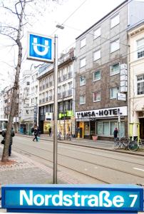 a sign on a pole on a city street at Hansa Hotel in Düsseldorf