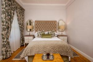 1 dormitorio con 1 cama grande y 2 mesas en Karos Gastehuis, en Loxton