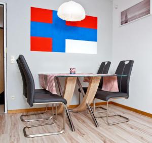 a dining room table with black chairs and a painting at Ferienwohnung in Damp Residenzblick an der Ostsee in Damp