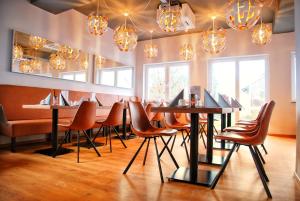 een restaurant met een tafel en stoelen en kroonluchters bij Walldorf Suites Boutique Hotel in Walldorf
