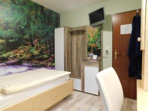Un dormitorio con una cama y un cuadro en la pared. en Pension Haus Petra, en Altenau