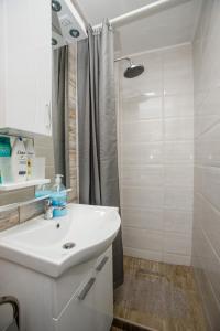 y baño blanco con lavabo y ducha. en 7 Days Premium Apartment, en Subotica