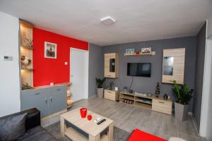 sala de estar con pared de acento rojo en 7 Days Premium Apartment, en Subotica