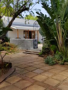 a house with a stone patio in front of a building at Hemel en Aarde Village Accommodation in Hermanus