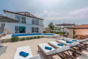 a patio with lounge chairs and a swimming pool at Luxury Villa Lavanda with Pool and Sauna in Kanfanar