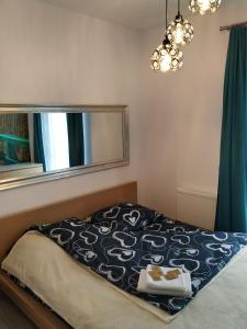 a bed with a black and white blanket on it at Apartament Przytulny Podolany in Poznań