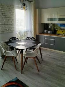 Apartament Przytulny Podolany في بوزنان: طاولة طعام وكراسي في مطبخ