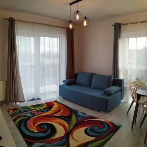 a living room with a blue couch and a colorful rug at Apartament Przytulny Podolany in Poznań