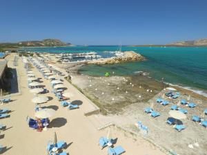an overhead view of a beach with umbrellas and the ocean at UNAHOTELS Club Hotel Ancora in Stintino