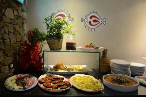 a buffet with many plates of food on a table at UNAHOTELS Club Hotel Ancora in Stintino