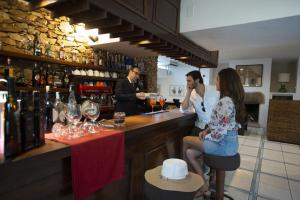 a group of people sitting at a bar at UNAHOTELS Club Hotel Ancora in Stintino