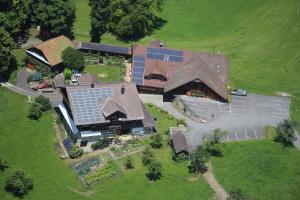 eine Luftansicht eines großen Hauses mit Sonnenkollektoren darauf in der Unterkunft Ferienhof Krinde in Ringoldswil