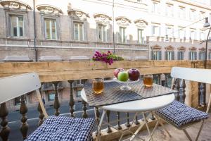 una mesa con fruta y bebidas en el balcón en Amazing Piazza Venezia Suites, en Roma