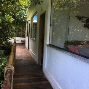 a wooden walkway leading to a door of a house at CASA RANXOXITA in Itaipava