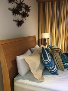 a bedroom with a bed with pillows on it at CASA RANXOXITA in Itaipava