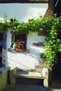 a building with a bench and flowers on it at Hotel Restaurant Zum Nachtwächter in Lienzingen