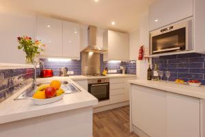 a kitchen with a bowl of fruit on a counter at Beachcombers Apartments in Newquay