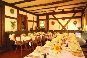 - une salle à manger avec de longues tables et des chaises fleuries dans l'établissement Hotel Restaurant Zum Nachtwächter, à Lienzingen